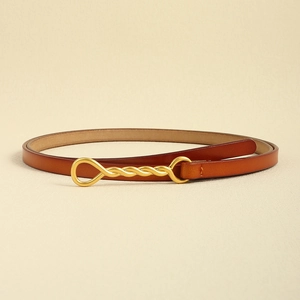 Dettaglio cintura in pelle marrone rossiccio con fibbia in metallo dorato ritorto vintage