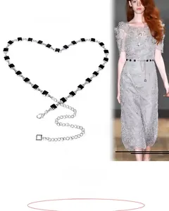 Detail of minimalist black square beaded waist chain with lobster clasp and extension link