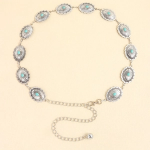 Détail d'une chaîne de taille argentée vintage avec incrustation de turquoise et motifs ethniques