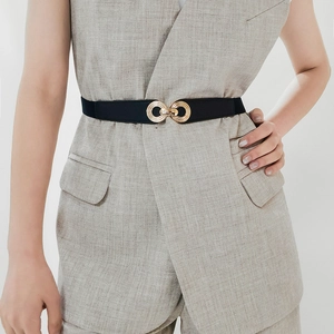 Close-up of a black elastic belt with a metallic gold interlocking double ring buckle
