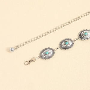 Détail d'une ceinture chaîne bohème argentée avec incrustations de turquoise et motifs vintage