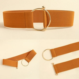 Detail of amber elastic wide waist belt with golden circular metal interlocking buckle