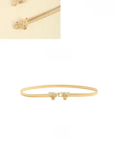 Detail of golden elastic belt with sparkling rhinestone leopard head metal buckle clasp