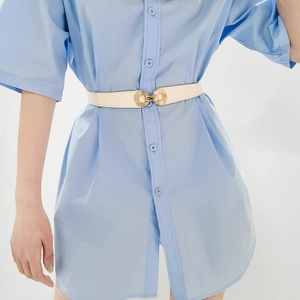Detailed close-up of a slim beige leather belt with a golden double ring metal buckle