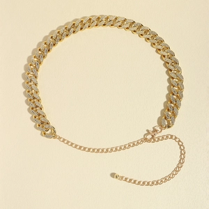 Detailed macro shot of gold rhinestone-studded cuban chain belt with lobster clasp