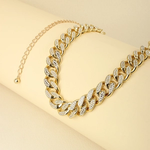 Detail of gold Cuban chain belt with rhinestone inlay and adjustable drop ball charm