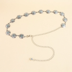 Détail d'une chaîne de taille bohème en métal avec perles turquoise et gravures fines