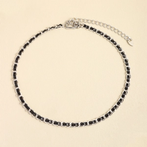 Minimalistische silberne Metallkette mit schwarzem Lederband und Herzanhänger-Detail