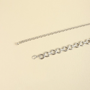 Detail shot of the silver infinity link metal waist chain with lobster clasp closure