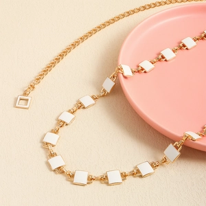 Golden metal waist chain featuring white square enamel blocks for dresses