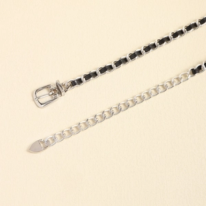 Details der silbernen Metallkette mit schwarzem Ledergeflecht und Herzanhänger