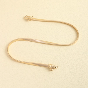 Detailed close-up of golden elastic metal waist chain with vintage leopard head buckle
