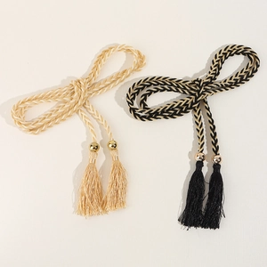 Close-up of woven tassel belts with gold beads in champagne and black gold colors