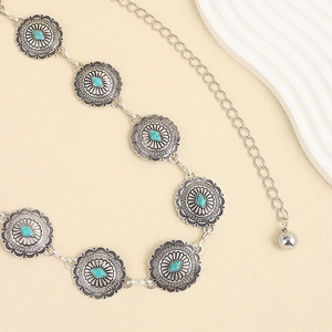 Détail de la ceinture bohème en turquoise avec disques argentés gravés et motifs floraux
