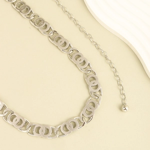 Detail view of silver metal waist chain featuring interlaced circles and lobster clasp