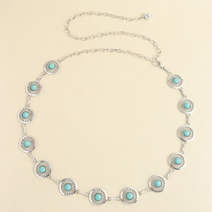 Détails d'une chaîne de taille argentée avec incrustations de turquoise et motifs gravés