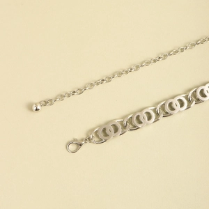 Detailed close-up of a silver chain belt with interlocking rings and adjustable lobster clasp