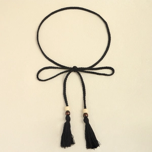 Detail of hand-woven black rope belt with wooden beads and long fringe tassels