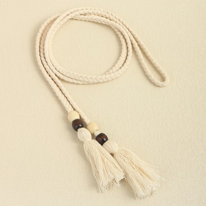 Detail of bohemian braided rope belt with fringe tassels and decorative wooden beads