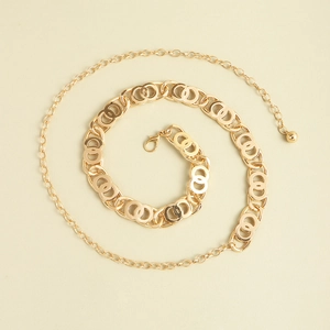 Macro view of golden double-ring chain belt with lobster clasp and ball pendant