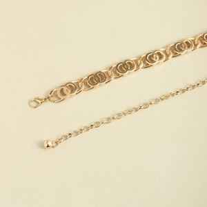 Detail of elegant gold chain belt with lobster clasp and adjustable metal ball pendant