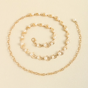 Détail d'une chaîne de taille en métal doré avec perles et breloques de feuilles