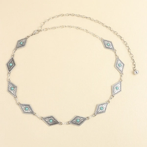 Détail d'une ceinture bohème avec pierres turquoise et plaques en losange gravées vintage