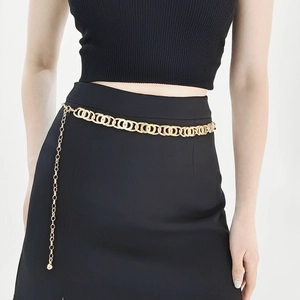 Detail of elegant gold multi-ring chain belt for women shown on a black dress waist