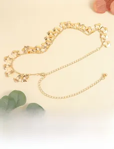 Detail of golden metal waist chain with hollow flower links and adjustable lobster clasp