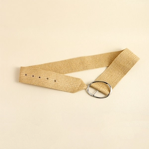 Detailed macro view of khaki straw woven belt texture and polished silver metal buckle