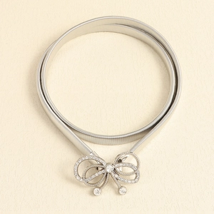 Close-up of silver elastic waist belt with sparkling rhinestone bow buckle detail
