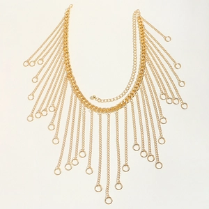 Close-up of gold layered tassel body chain with round pendant and thick curb links