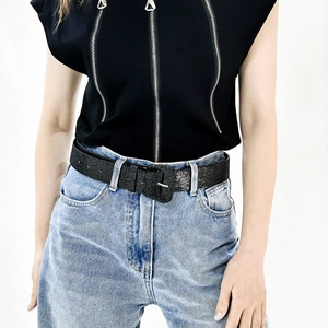Detailed close-up of a Y2K style black glitter belt with a textured square metal buckle