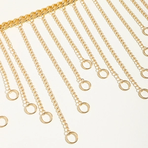 Detailed macro view of golden metal fringe body chain with sleek circular pendants