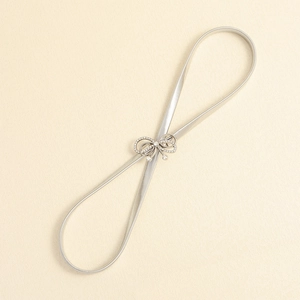 Detailed view of silver elastic metal waist chain with sparkling butterfly bow buckle