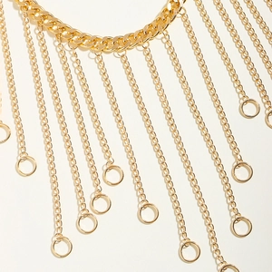 Detail of layered gold fringe body chain featuring thick links and circular pendants