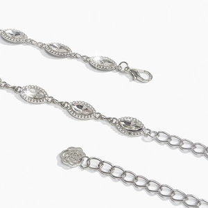Dettaglio macro della cintura a catena argento con strass marquise e ciondolo a rosa