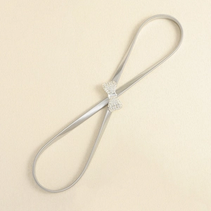 Detail of silver elastic metal waist chain featuring a sparkling crystal bow buckle