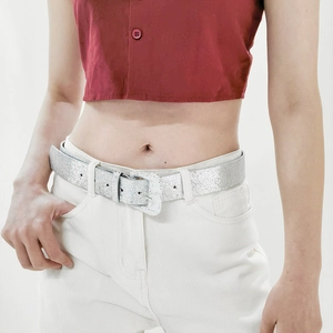 Close-up of a sparkling silver Y2K glitter belt with a square metal buckle on jeans