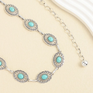 Détail de ceinture chaîne argentée avec incrustations turquoise et motifs ethniques