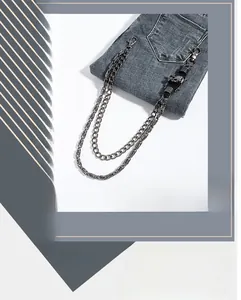 Detail of heavy punk hip-hop wallet chain with silver skulls on dark denim jeans