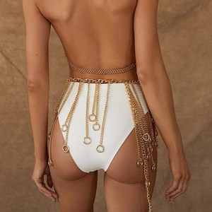 Detail of gold body chain with layered tassels and round pendants on female back