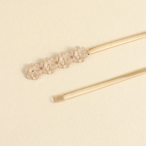 Detailed close-up of golden elastic metal waist chain with elegant flower-shaped buckle