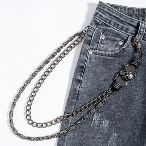 Detailed view of layered punk skull pants chain featuring mixed metal links on denim