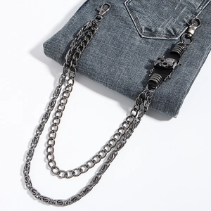Close-up of gunmetal punk pants chain with skull charms on dark blue denim jeans