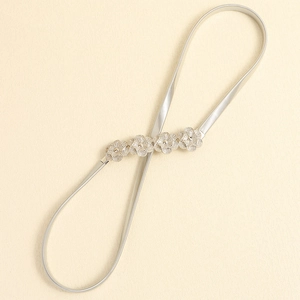 Detail of silver elastic metal belt featuring four elegant hollow flower ornaments