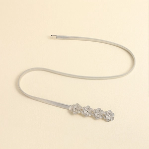 Detail of silver stretch metal waist belt featuring four intricate hollow flower buckles