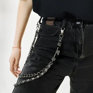 Detail of layered punk skull pants chain with metal buckles on black jeans