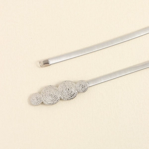 Detail of silver elastic metal waist chain with textured circular decorative buckle