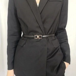 Detail of elegant black slim leather belt with a golden double ring buckle on a blazer